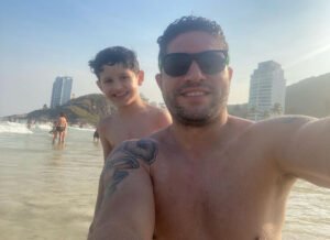 menino e homem com óculos escuros olham para a câmera
